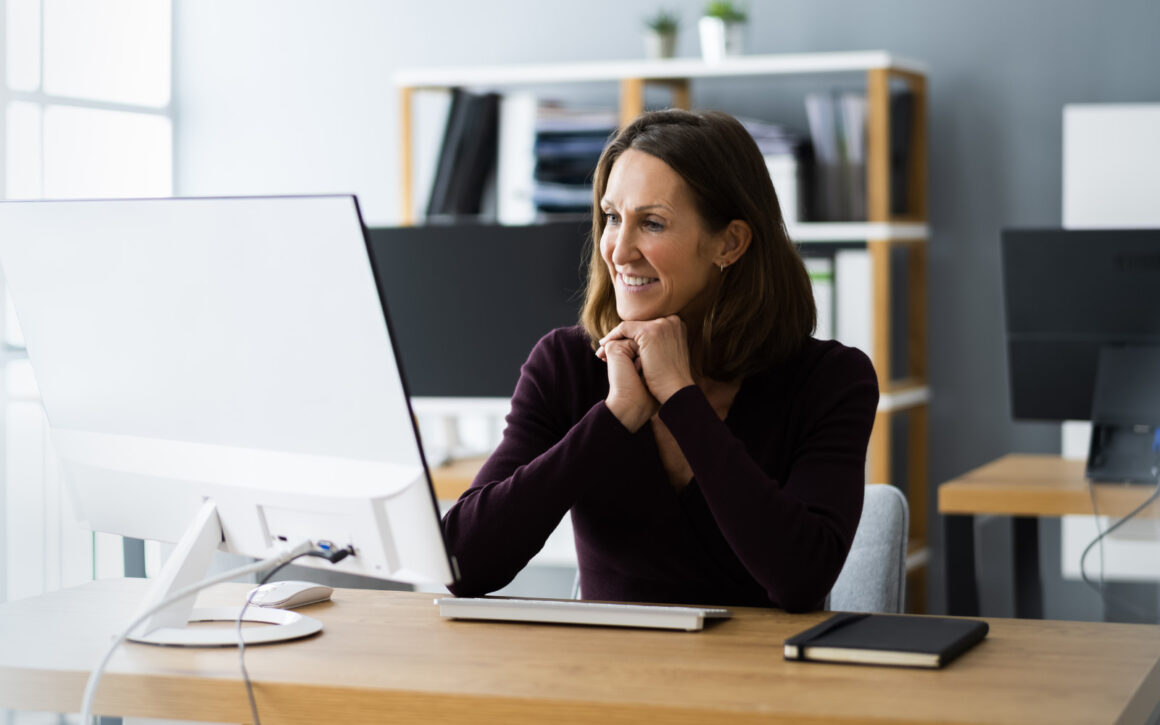 Eine Frau sitzt vor einem PC-Bildschirm